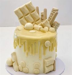 a white cake with yellow icing and lots of candies on top