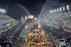 an aerial view of a large group of people in front of a stage with water spraying from it