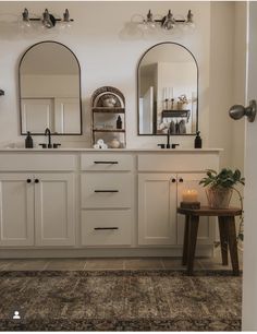 a bathroom with double sinks and mirrors on the wall above it is decorated in white