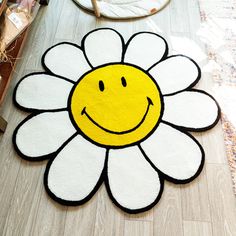 a rug with a smiley face on it in the shape of a flower is shown