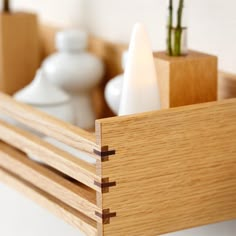 a close up of a wooden object with two small vases in the back ground