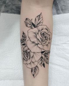 a black and white rose tattoo on the right arm, with leaves around it's edges