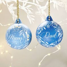 two blue christmas ornaments with the word mum and dad written on one ornament