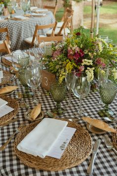 the table is set with place settings and utensils for an outdoor dinner party