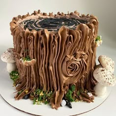 there is a cake that looks like it has been carved into a tree stump with leaves and mushrooms around it