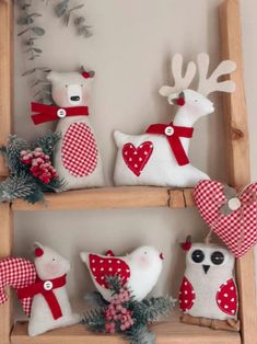 some stuffed animals are sitting on wooden shelves with red and white plaid bow ties around them