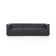 a black leather couch with buttons on the back and arms, in front of a white background