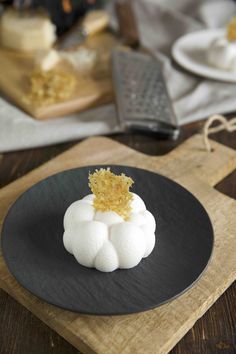 a black plate topped with food on top of a wooden cutting board