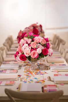 a long table with pink and red flowers on it