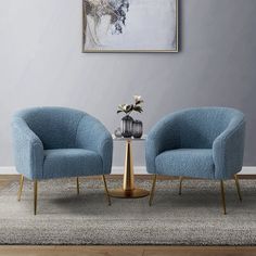 two blue chairs sitting next to each other on top of a rug