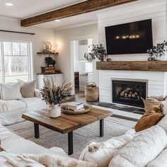 a living room filled with furniture and a flat screen tv mounted on the wall above a fire place