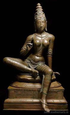 a statue of a woman sitting on top of a wooden box with her legs crossed