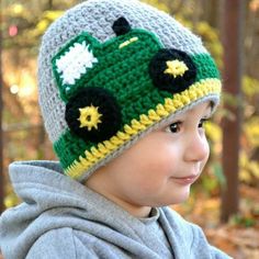 a young boy wearing a green and yellow crocheted hat with stars on it