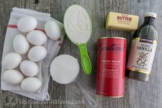 eggs, butter, and other ingredients are laid out on a wooden table to be used for baking