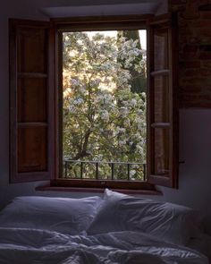 a bed sitting under a window next to a white blanket on top of a bed