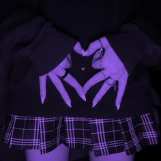 two hands in the shape of a heart on top of a black and white checkered skirt