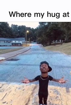 a young boy standing in the middle of a road with his arms out and hands outstretched