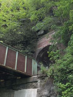 an old train bridge over a stream in the woods