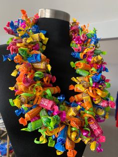 a black mannequin with multicolored candy on it's neckline