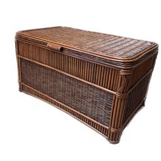 a large wicker chest with lid and handles on the front, sitting against a white background