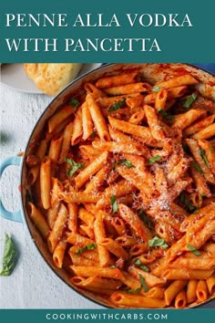 pasta with sauce and parmesan cheese in a blue pan next to garlic bread