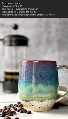 a coffee cup sitting on top of a table next to some coffee beans and an espresso machine