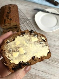 a person holding a piece of bread with butter on it