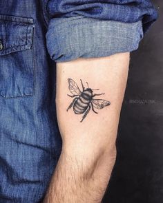 a man's arm with a tattoo of a bee on the back of his arm