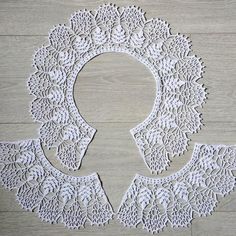 a white doily with an oval shaped object in the middle on a wooden floor