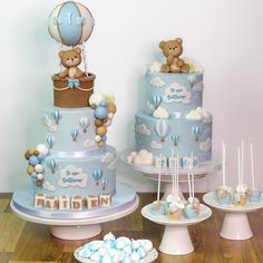 a baby shower cake with balloons and teddy bears on top, surrounded by cupcakes