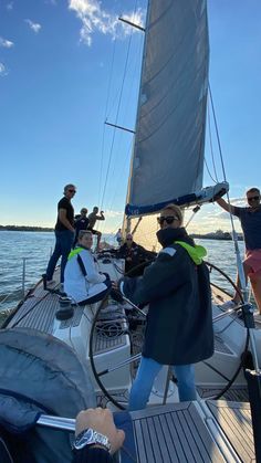 some people on a sailboat in the water and one person is taking a photo