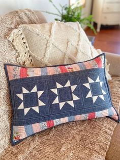 a blue pillow with white stars on it sitting next to a brown chair in a living room