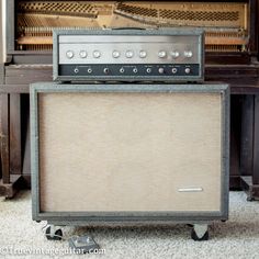 an old amp sitting in front of a piano