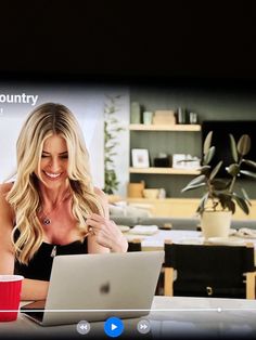 a woman sitting at a table with a laptop computer in front of her on the screen