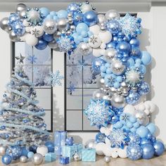 blue and silver christmas decorations in front of a window