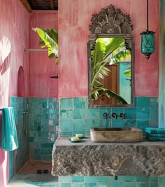 a bathroom with pink walls and blue tiles on the floor, along with a stone sink