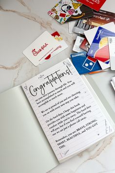 there are many different cards on the table with paper attached to each card and one has a note that says congratulations