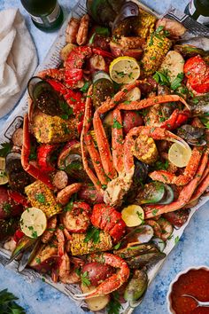 a platter filled with lobsters, mussels and corn on the cob