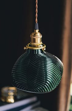 a green glass light hanging from a ceiling