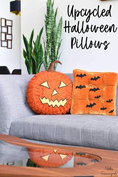 an upcycled halloween pillow is sitting on a couch next to a potted plant