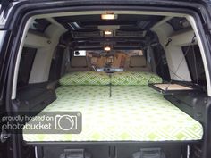 the back end of a van with two beds in it