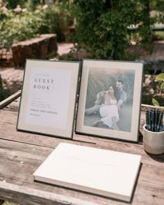 two framed photos sitting on top of a wooden table