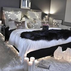 a bedroom decorated in black and white with lights