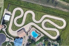 an aerial view of a skate park and swimming pool in the middle of a grassy area