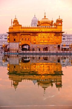 the golden building is reflected in the water