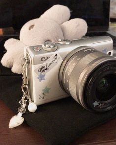 a camera with a white teddy bear sitting on top of it