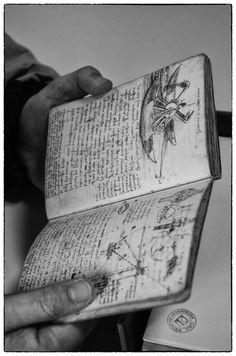 a person holding an open book with drawings on it