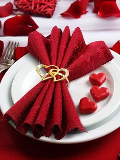 a white plate topped with red napkins covered in hearts