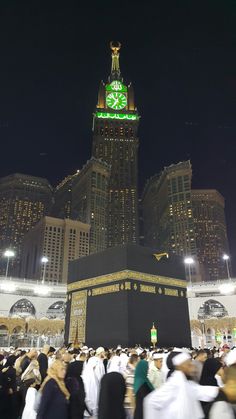 a large group of people standing in front of a building with a clock on it