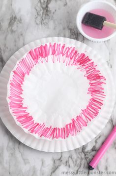 a paper plate with some pink sticks on it